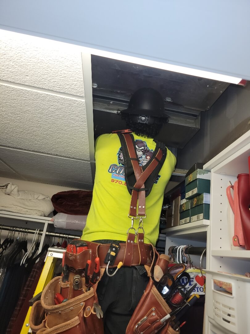 people working on an hvac unit in an empty building