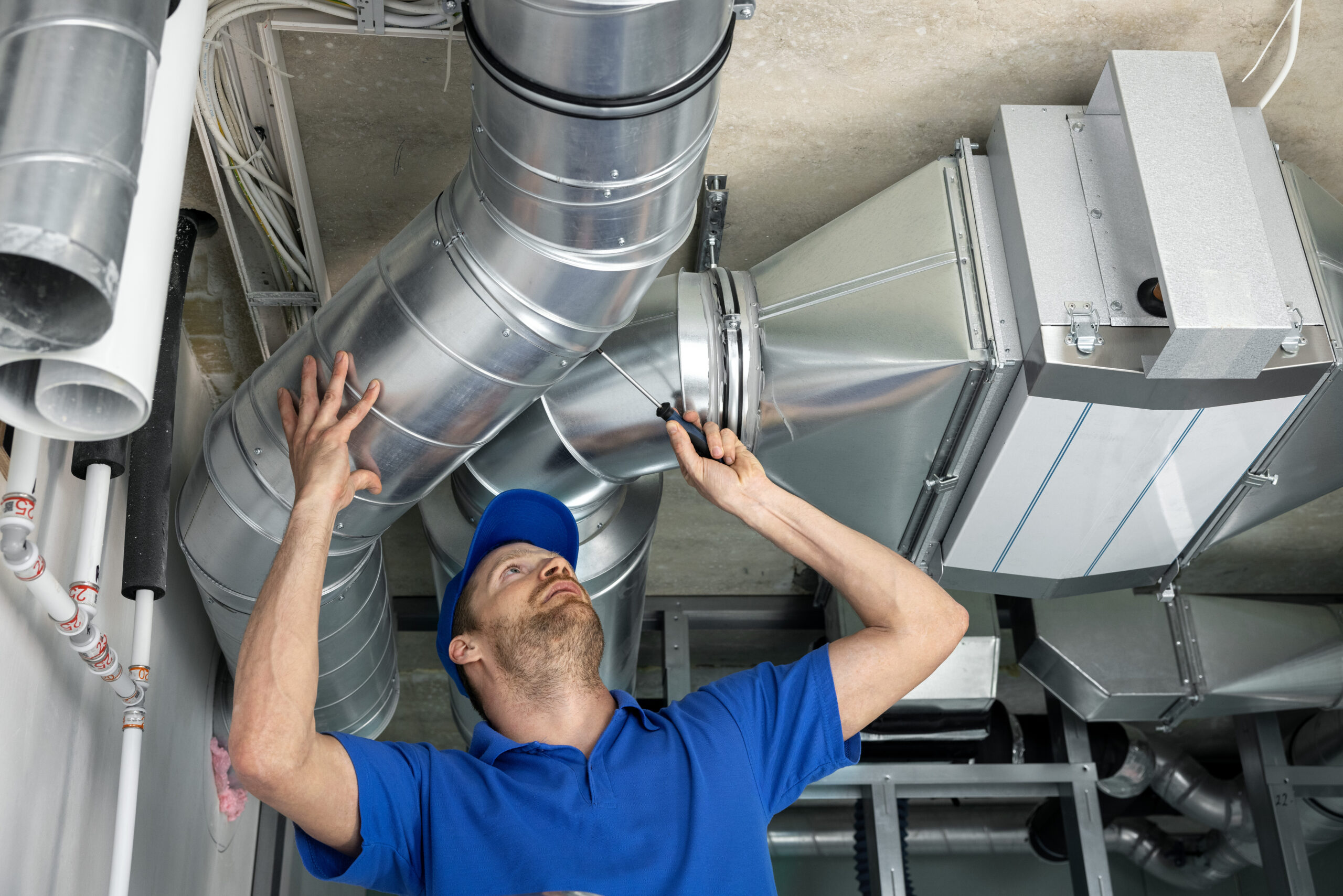 people working on an hvac unit in an empty building